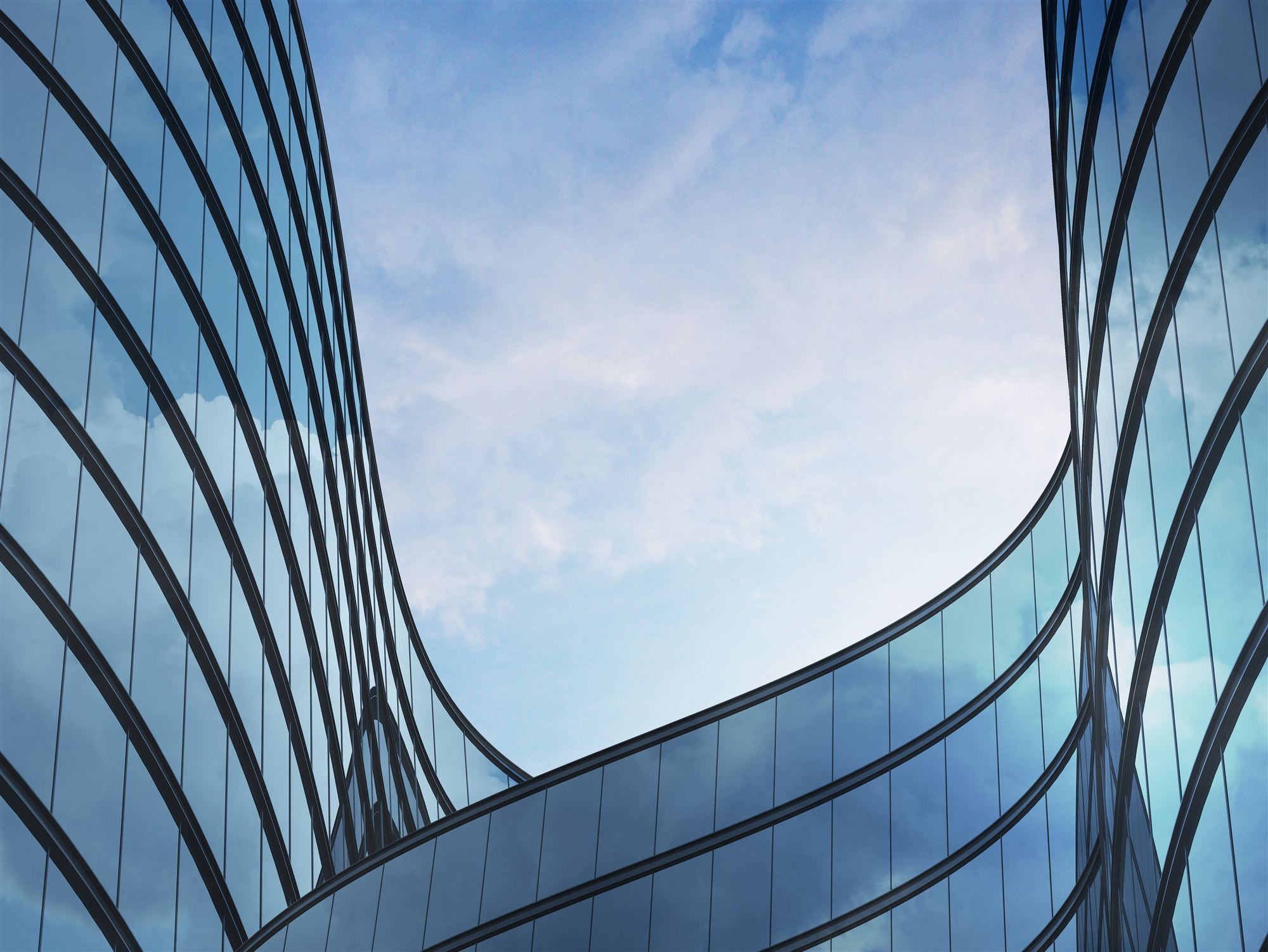 Curved glass office towers against blue sky
